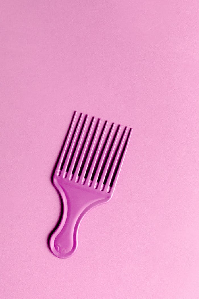 A purple comb laid against a light pink background for a vibrant aesthetic.