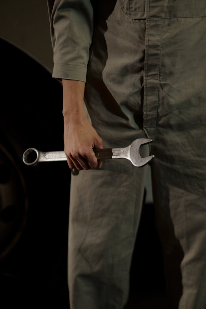 Close-up of an auto mechanic holding a wrench in a workshop setting.